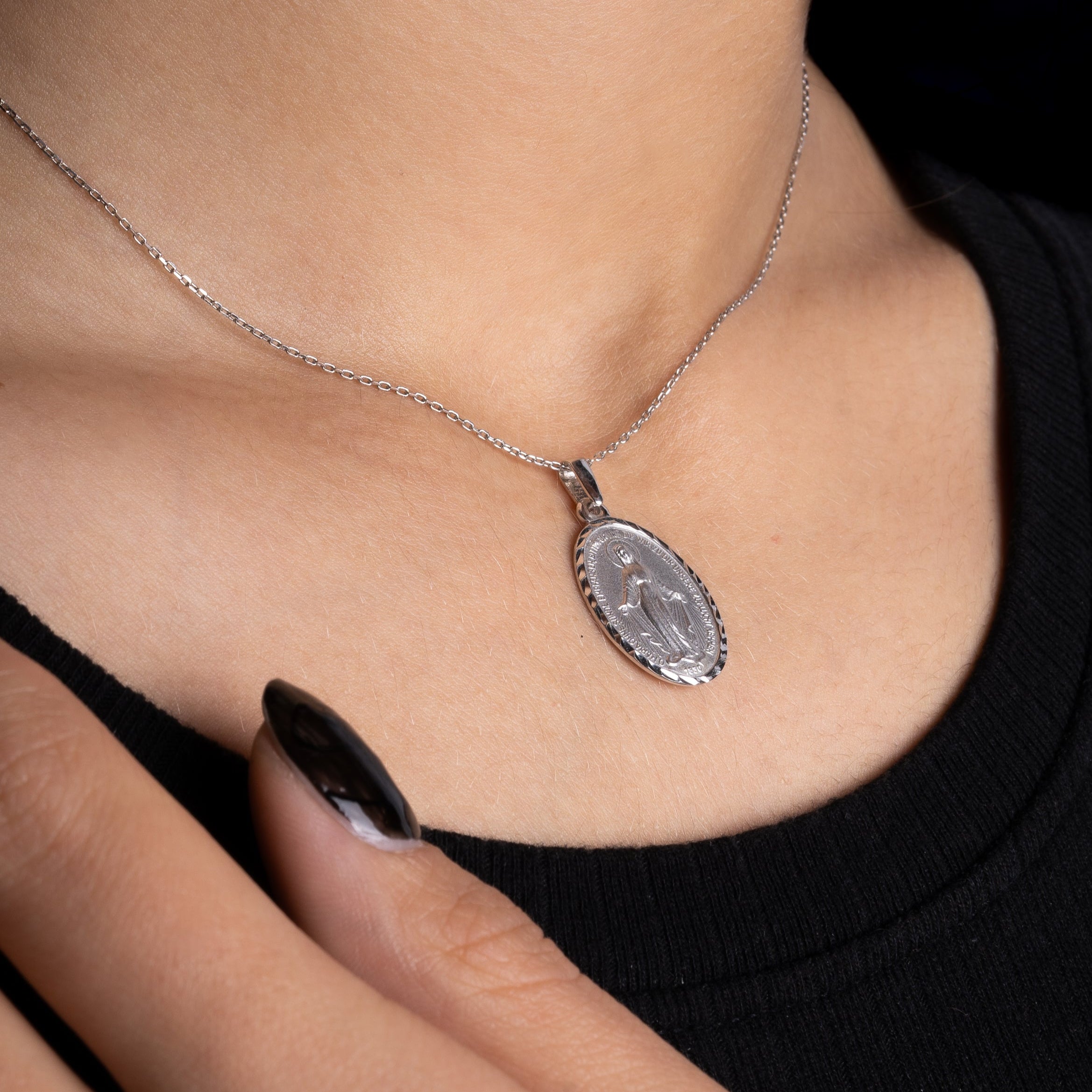 Madonna Halskette Silber am Hals getragen, ovaler Anhänger mit Zirkonia im Detail.