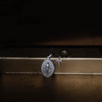 Madonna Anhänger Silber neben Kreuzanhänger und Ring, stilvolles Schmuck-Arrangement.