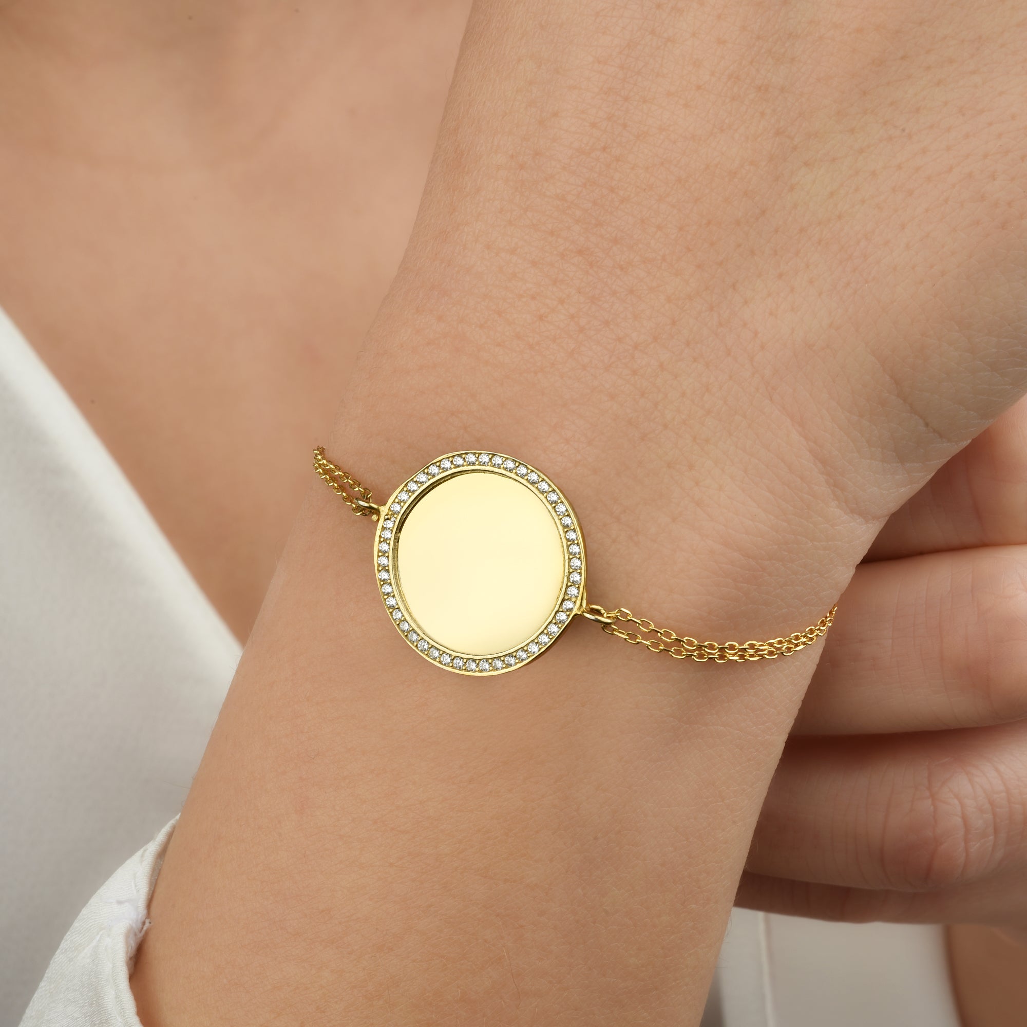 Nahaufnahme: gravierbares Gold-Armband mit Zirkonia-Rand am Handgelenk, elegant & minimalistisch.