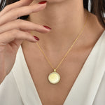 Model trägt Mirror Gravur Kette in Gold, runder Coin Anhänger mit Zirkonia – elegant am Dekolleté.