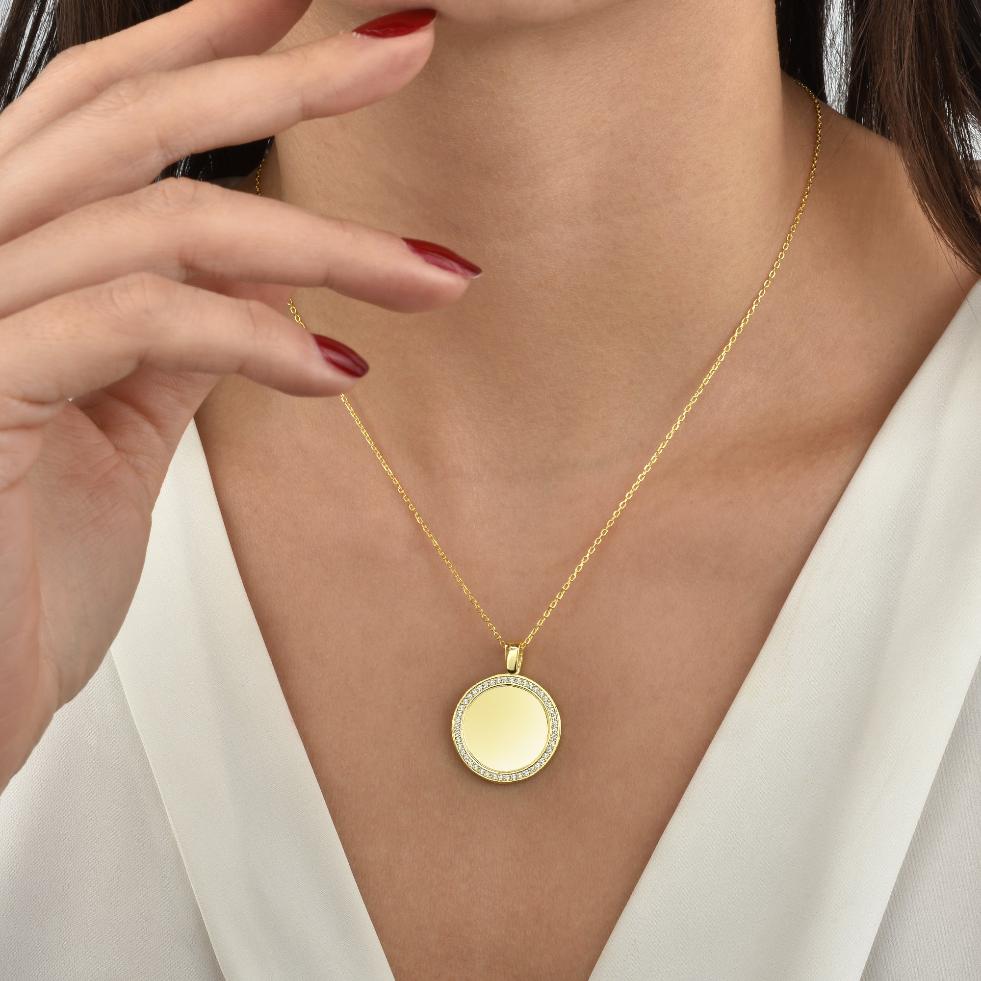 Model trägt Mirror Gravur Kette in Gold, runder Coin Anhänger mit Zirkonia – elegant am Dekolleté.