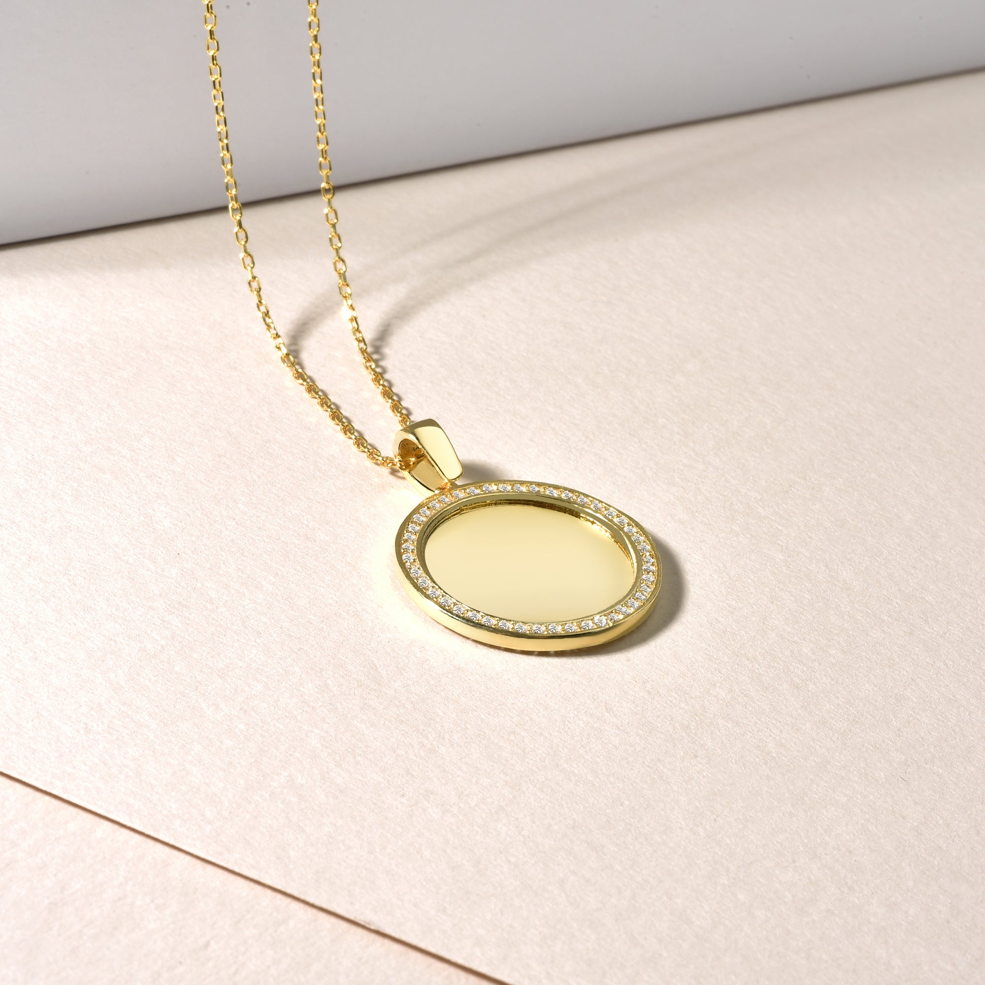 Mirror Gravur Kette Gold liegend, Coin Anhänger mit Zirkonia-Rahmen – glänzende Gravurfläche.