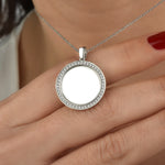 Nahaufnahme der silbernen Mirror Gravur Kette zwischen Fingern mit rotem Nagellack.