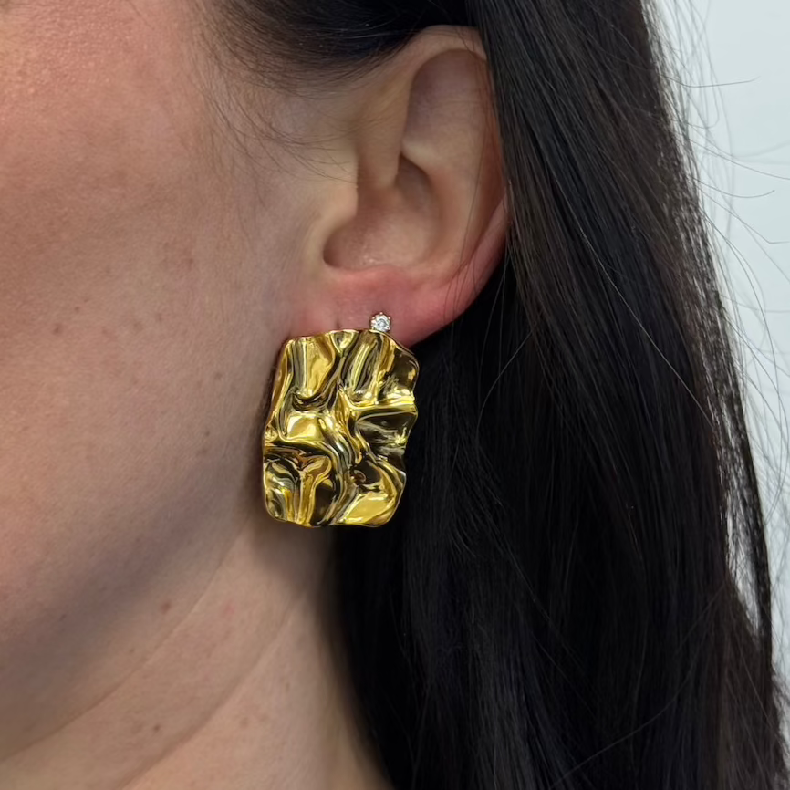 Goldene Steel Grace Ohrstecker am Ohr getragen, rechteckig strukturiert, glänzende Oberfläche