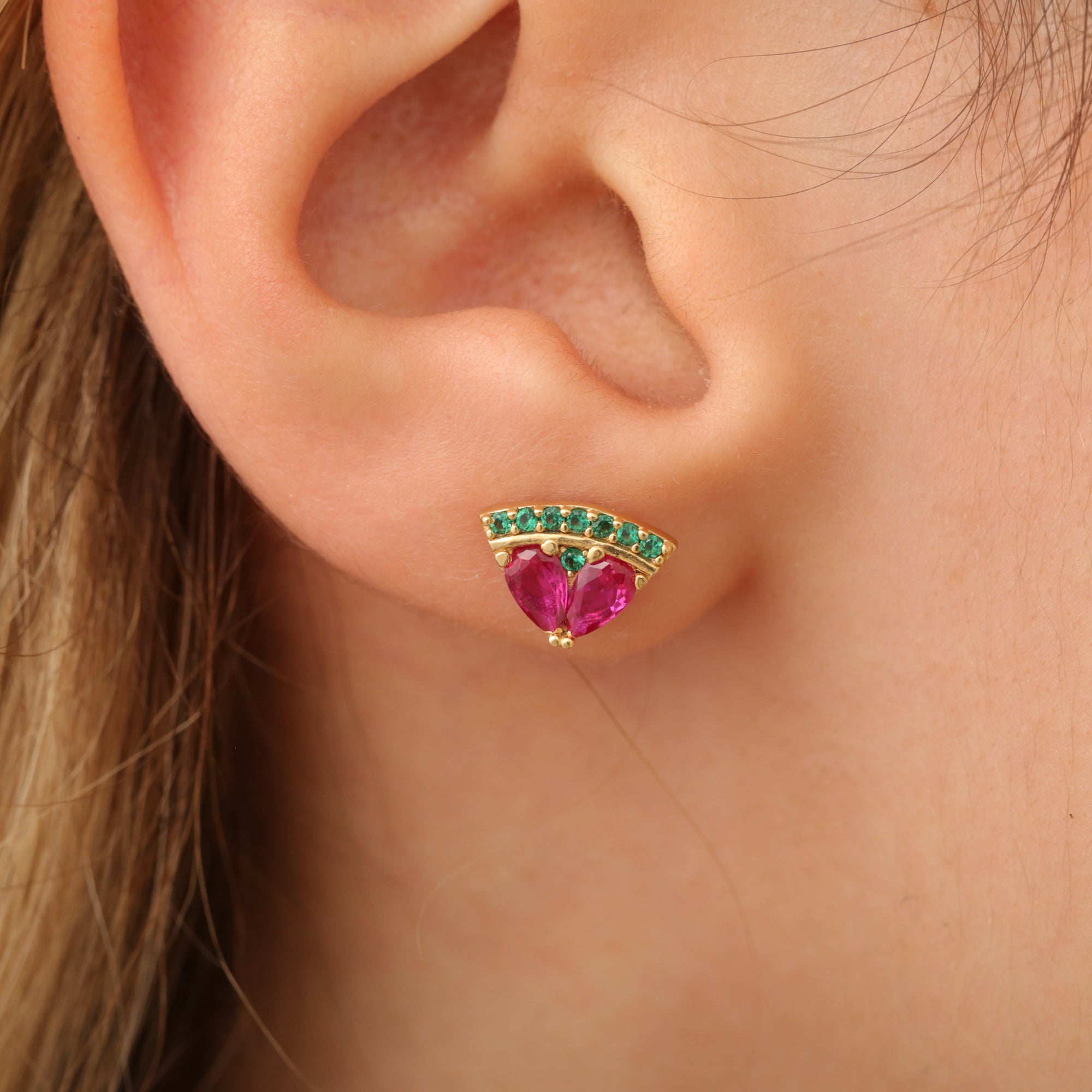 Wassermelone-Ohrstecker am Ohr, Halbkreis mit rosa und grünen Steinen.