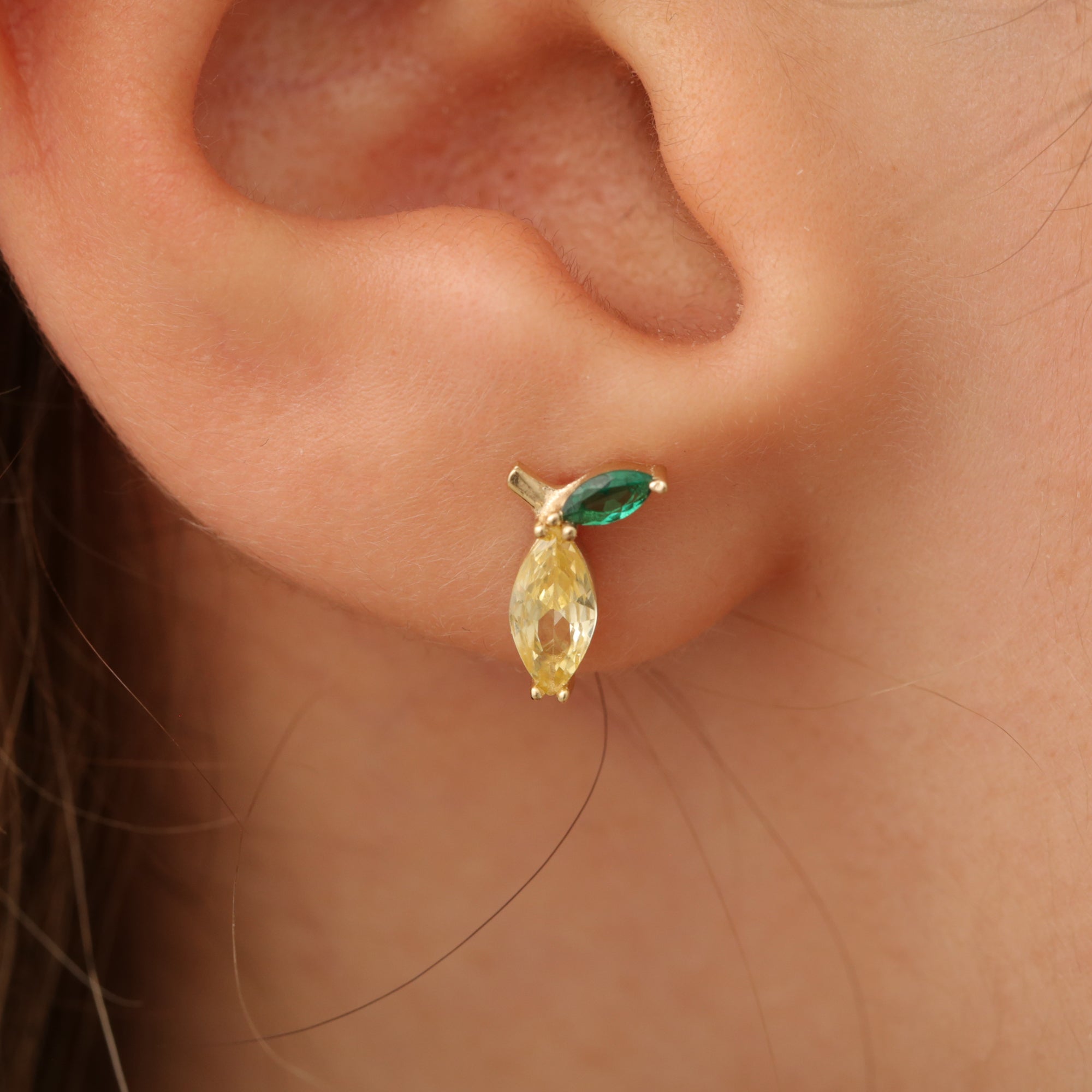 Zitrone-Ohrstecker am Ohr, Stein gelb mit grünem Blatt, 14K vergoldete Fassung.