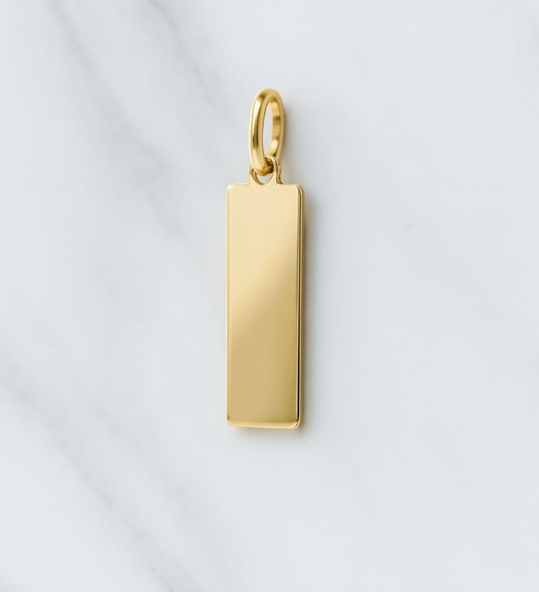 18K vergoldeter Paris Charm rechteckiger Anhänger auf Marmor