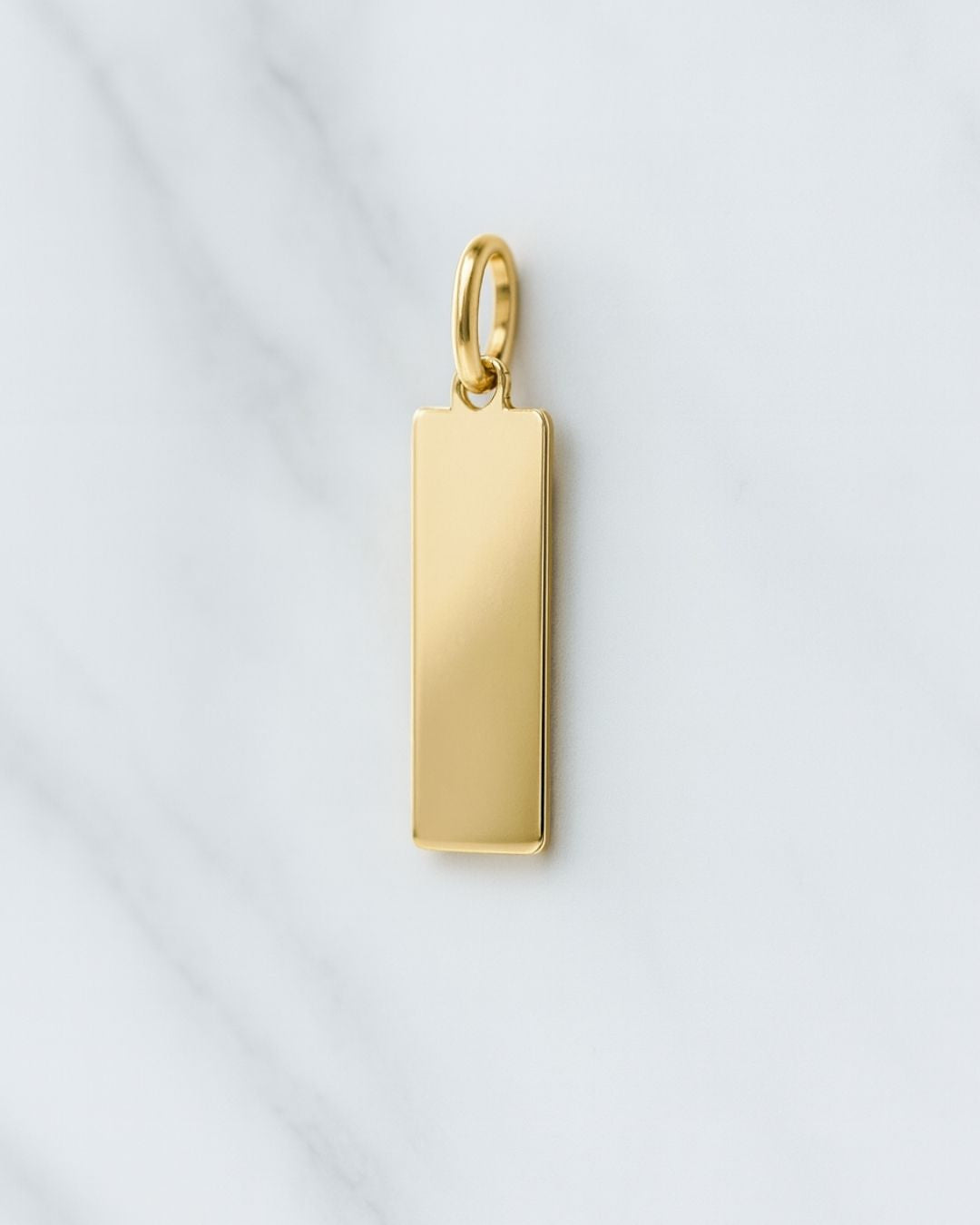 18K vergoldeter Paris Charm rechteckiger Anhänger auf Marmor