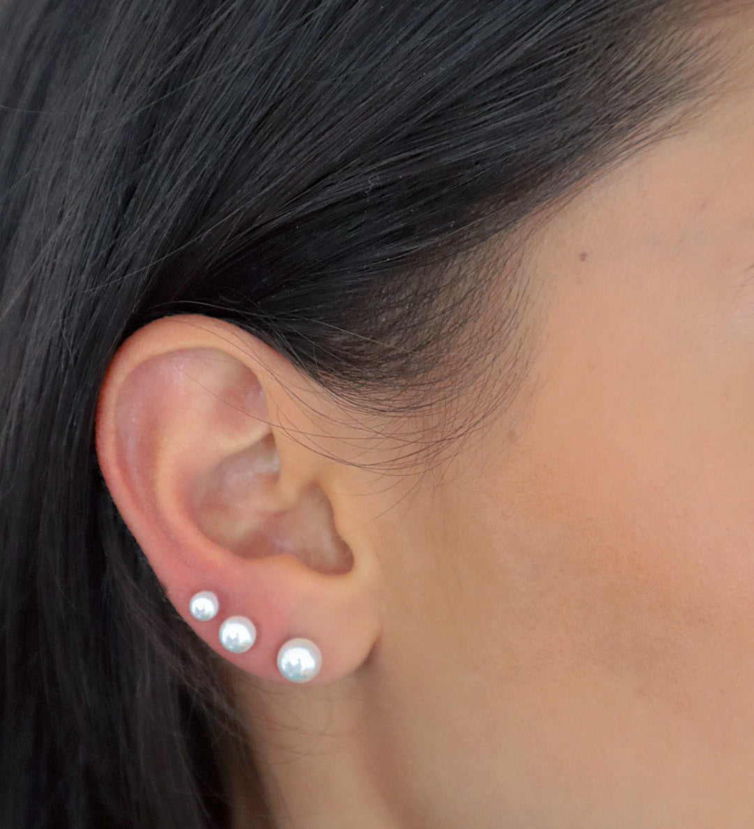 Pearl Balls M Stud Perlen Ohrstecker in Gold im Ear-Stack an weiblichem Ohr.