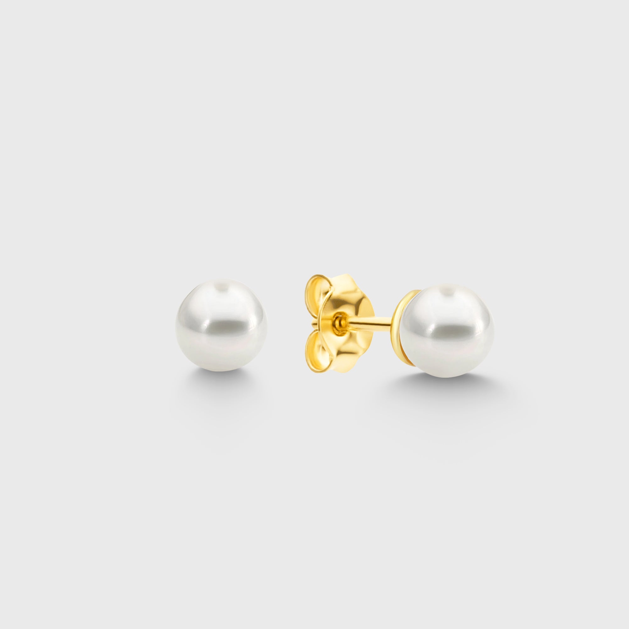Pearl Balls M Stud Perlen Ohrstecker in Goldoptik aus 925 Sterling Silber vor hellem Hintergrund.