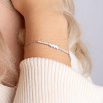 Pearl X Baguette Armkette Silber mit Perlen und Zirkonia an weiblichem Handgelenk.