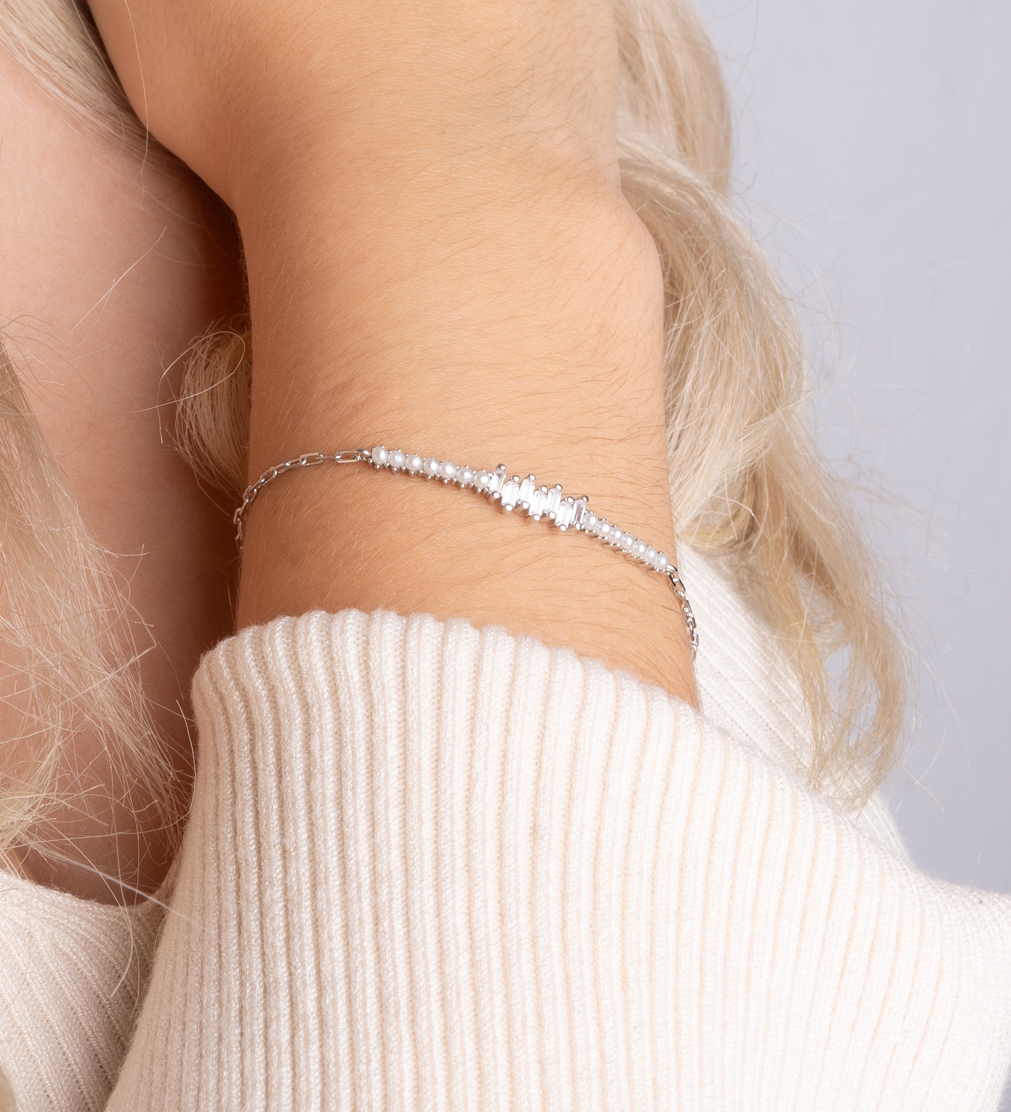 Pearl X Baguette Armkette Silber mit Perlen und Zirkonia an weiblichem Handgelenk.