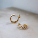 Pearl X Baguette Earring Gold: kleine Creolen mit Perlenreihe und Baguette-Zirkonia, Makroaufnahme.