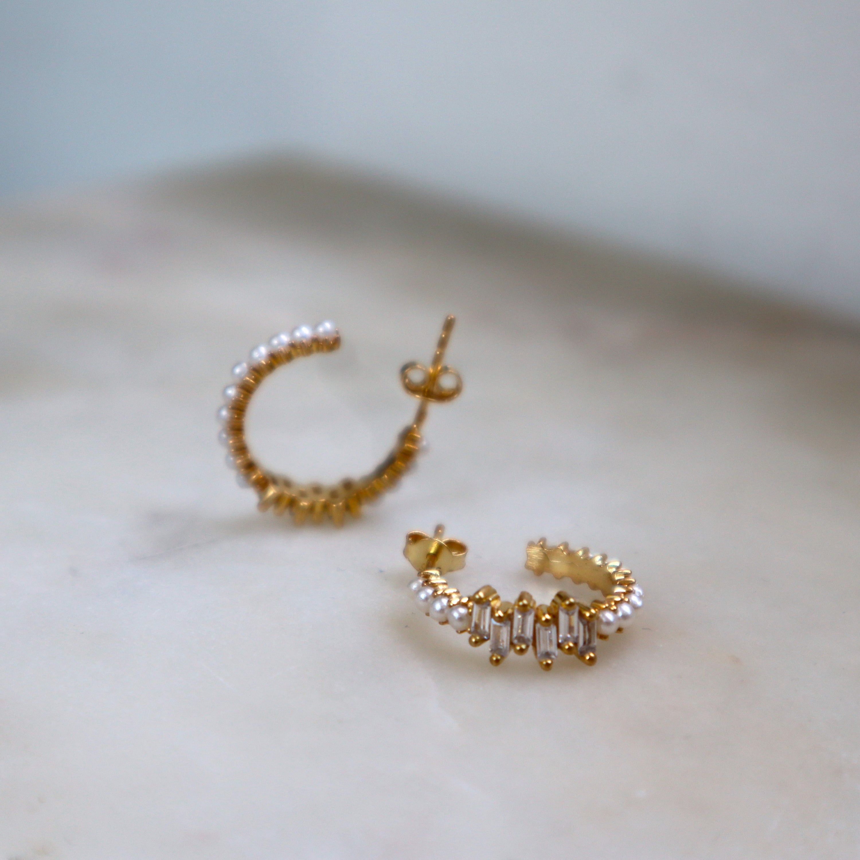 Pearl X Baguette Earring Gold: kleine Creolen mit Perlenreihe und Baguette-Zirkonia, Makroaufnahme.