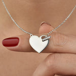 Nahaufnahme der Silber Herz Gravur Shiny Closure Kette zwischen Fingern gehalten.