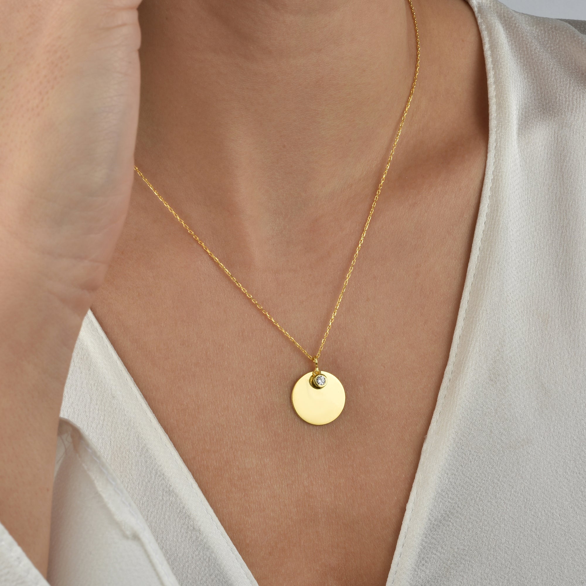 Goldene runde Halskette mit Stein Anhänger getragen am Dekolleté – elegant & minimalistisch.