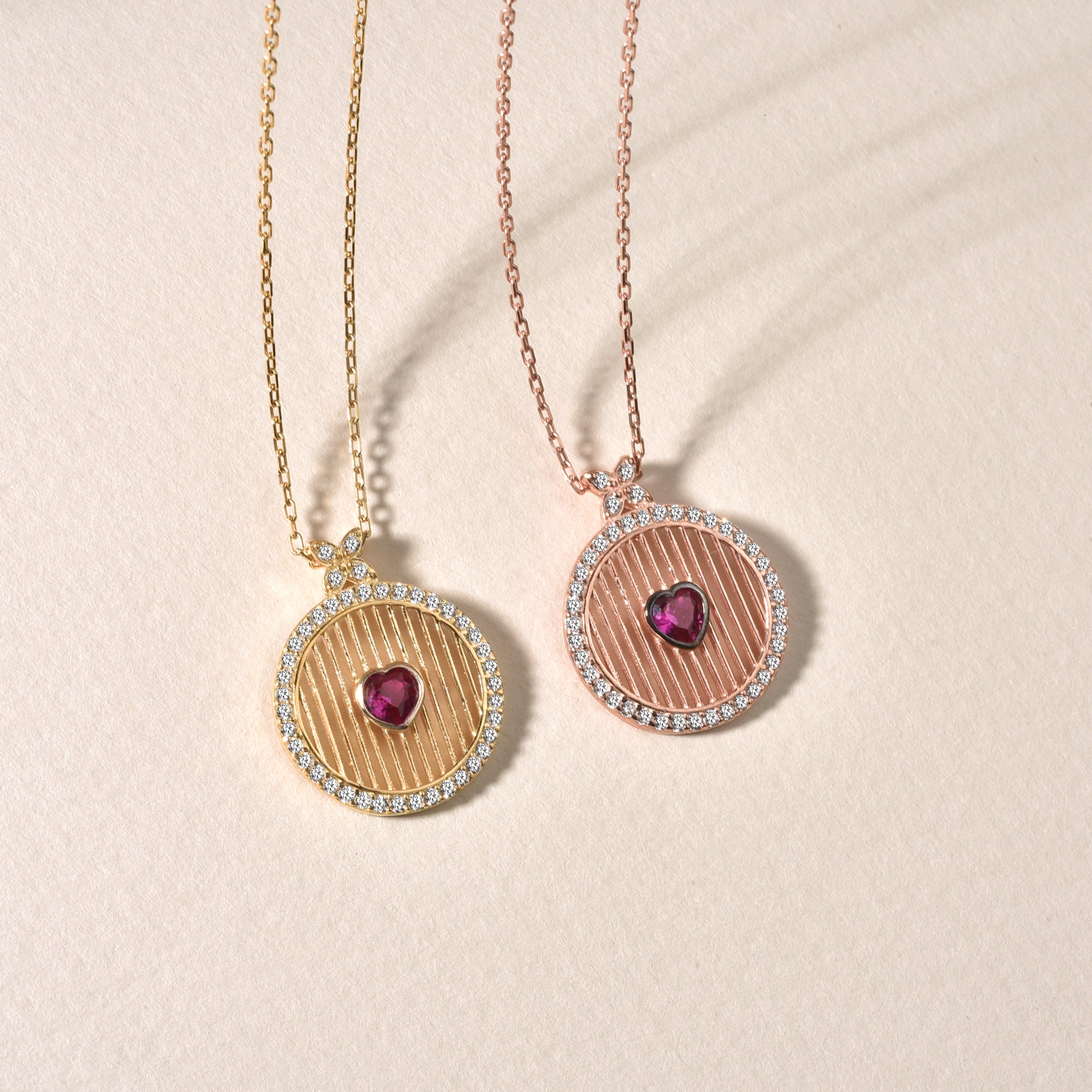 Gold & Rosé: Runde Herz-Kette mit rotem Zirkonia im Vergleich: Gold und Rosé Variante nebeneinander