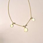 Minimalistische Runde Plättchen Kette Gold – drei Coins, vergoldete 925 Silberkette auf hellem Hintergrund.