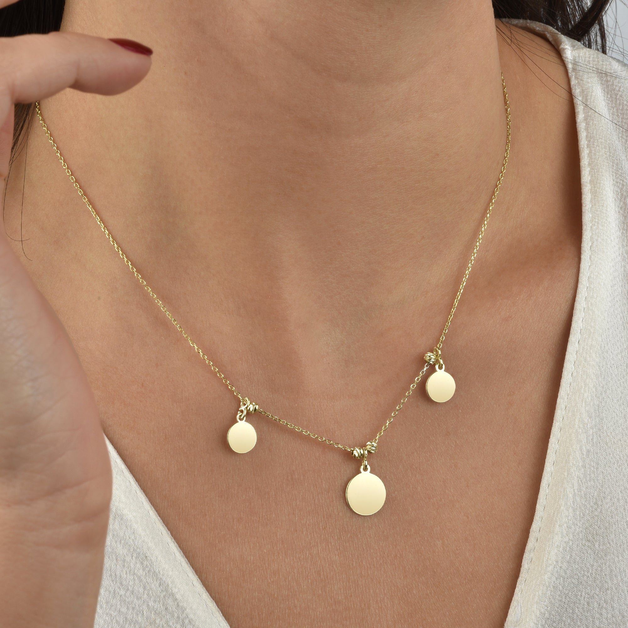 Goldene Coin-Kette mit drei runden Plättchen am Hals getragen – minimalistischer Damenschmuck.