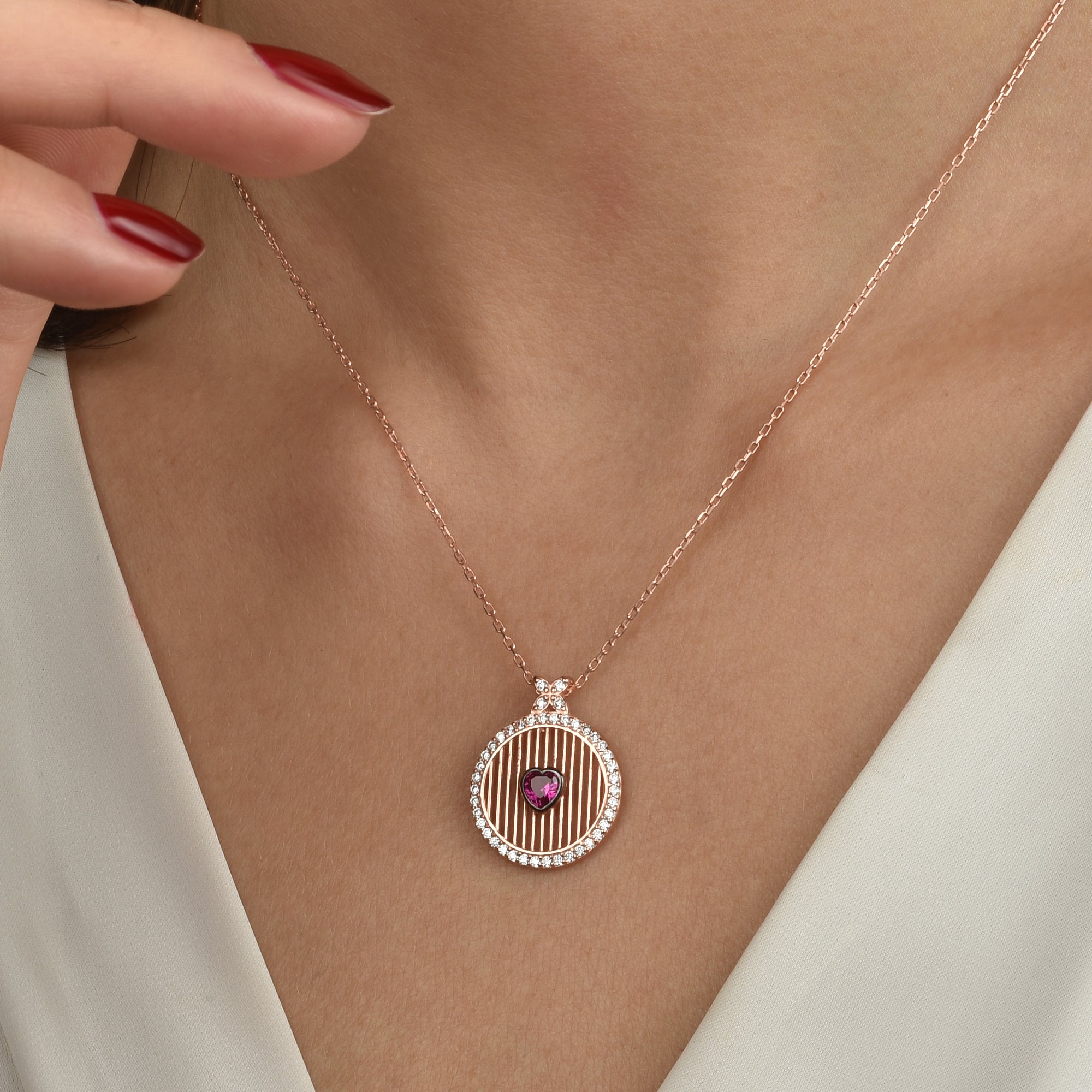 Detailaufnahme Runde Rosé Kette mit rotem Herz-Stein, vergoldete Halskette, eleganter Damenschmuck