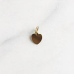 Goldener Santorini Charm in Herzform, 18K vergoldet, minimalistisch und elegant auf hellem Hintergrund.