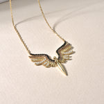 Schutzengel Kette Gold auf Stoff liegend – Detailansicht Engel-Flügel Anhänger mit Zirkonia-Mix.