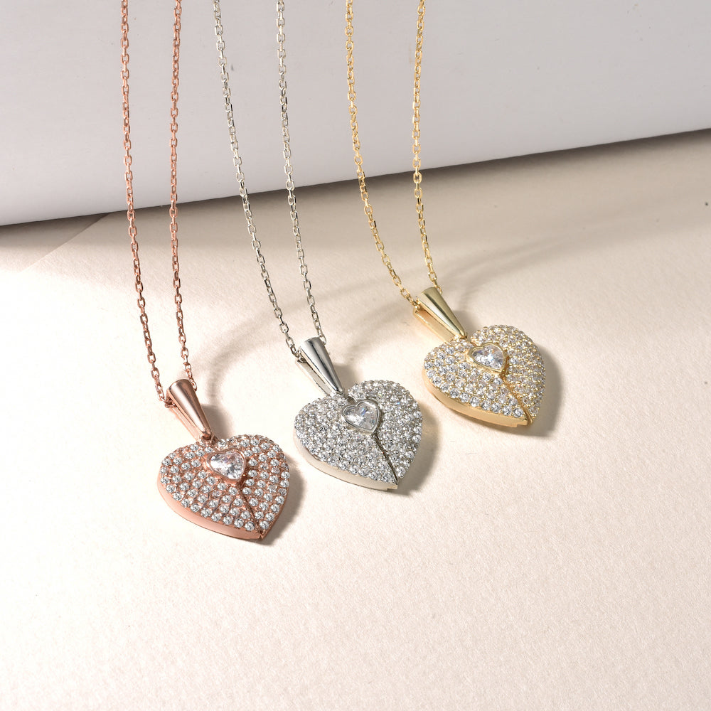 Drei Secret Heart Ketten in Rosé, Silber und Gold nebeneinander auf hellem Untergrund.