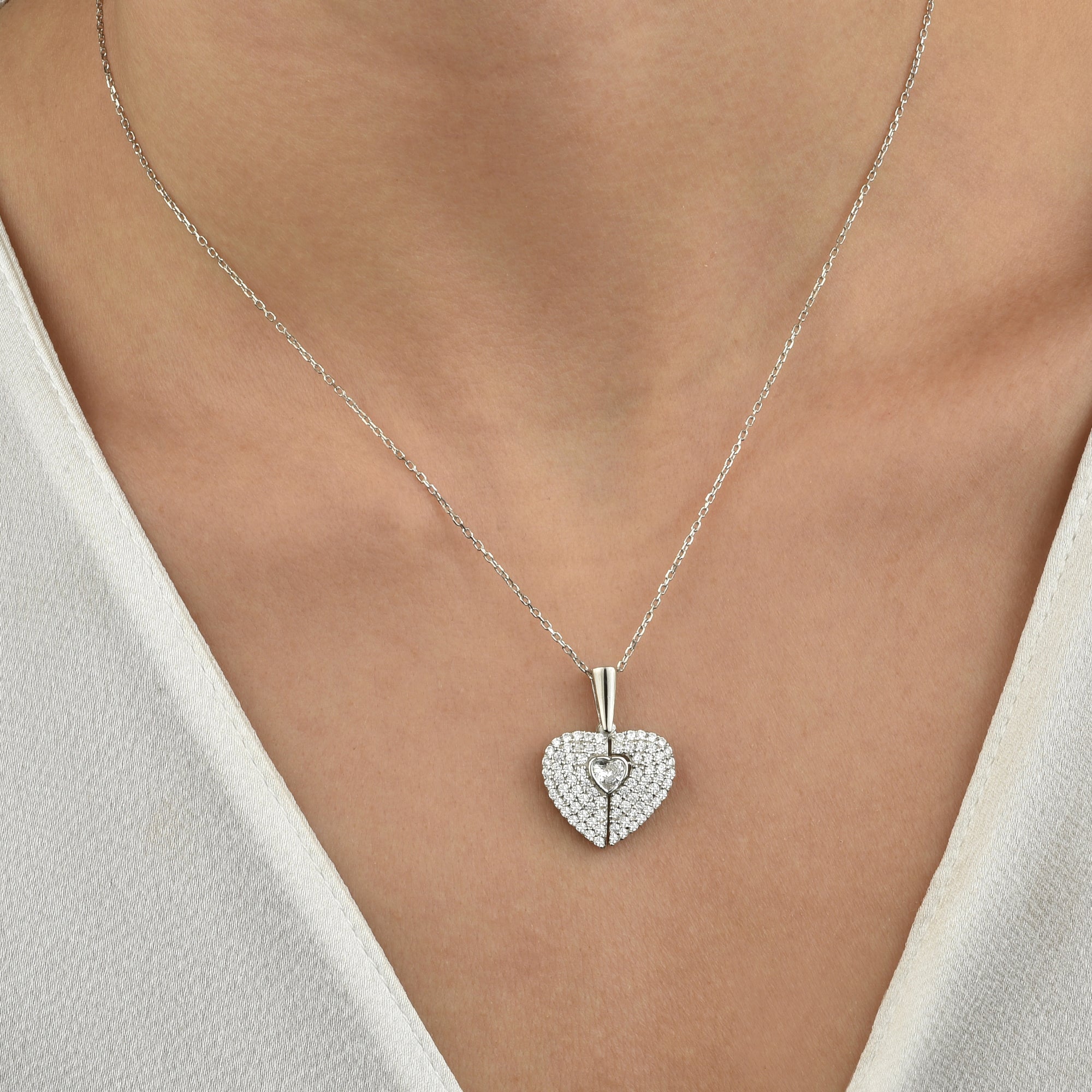Secret Heart Kette in Silber getragen am Hals einer Frau, elegantes Dekolleté.