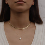 Model trägt Sleek Halskette Gold als Choker, kombiniert mit feiner Anhänger-Kette.