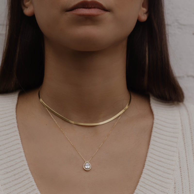 Model trägt Sleek Halskette Gold als Choker, kombiniert mit feiner Anhänger-Kette.