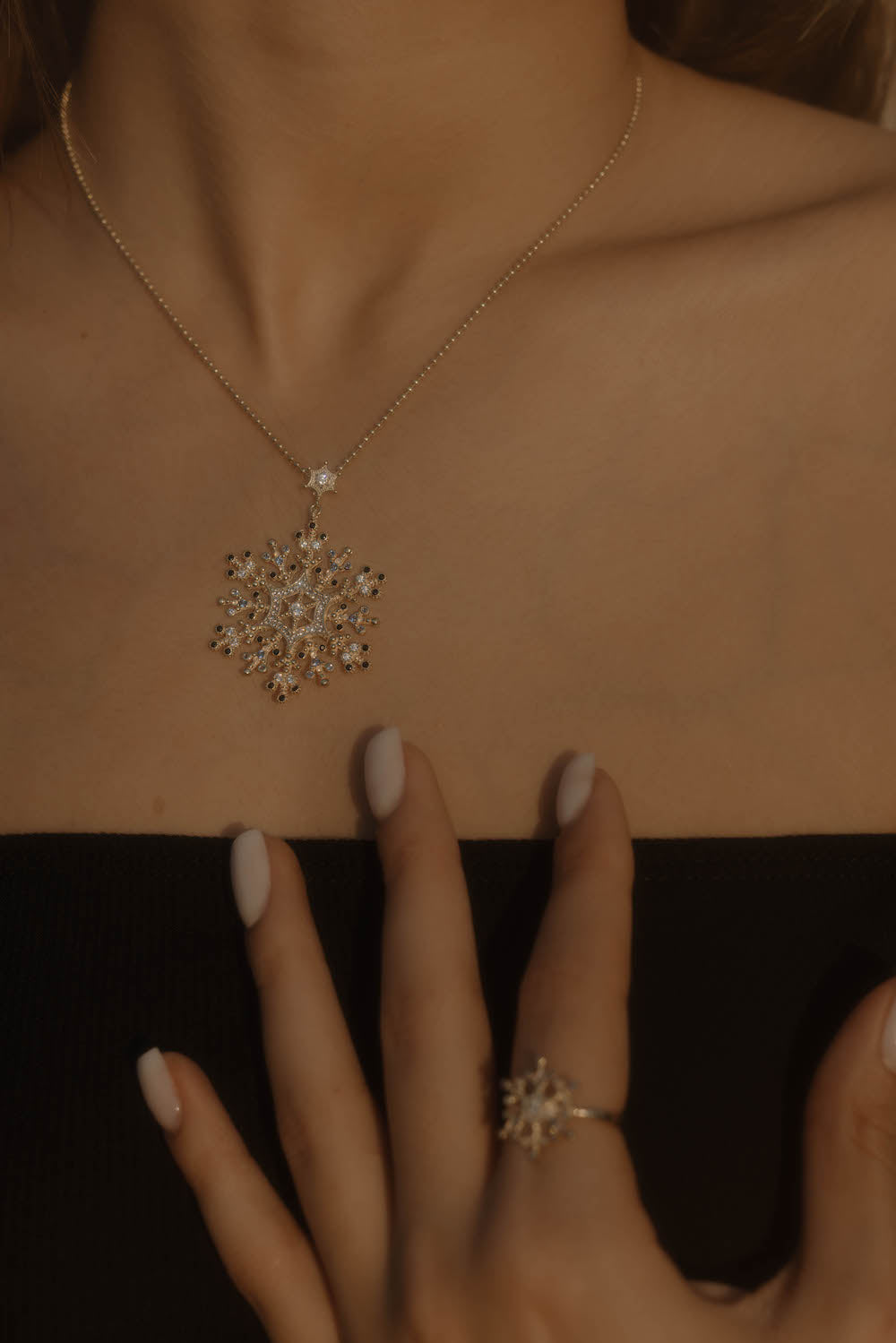 Detailaufnahme Snowflake Ice Halskette Gold am Dekolleté – Zirkonia-Mix im Schneeflocken-Design.