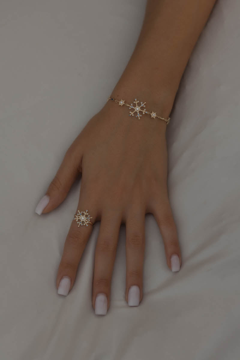 Snowflake Ice X Armkette Gold am Handgelenk, kombiniert mit passendem Schneeflocken-Ring, Zirkonia funkeln.