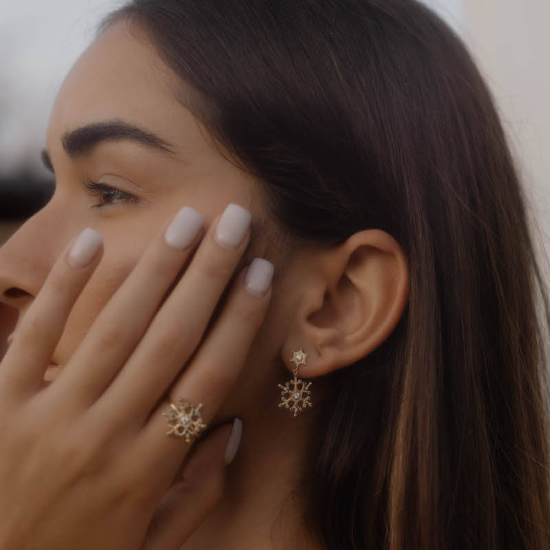 Model im Profil mit Snowflake Ice X Ohrringen Gold – eleganter Look mit Schneeflocken-Schmuck.