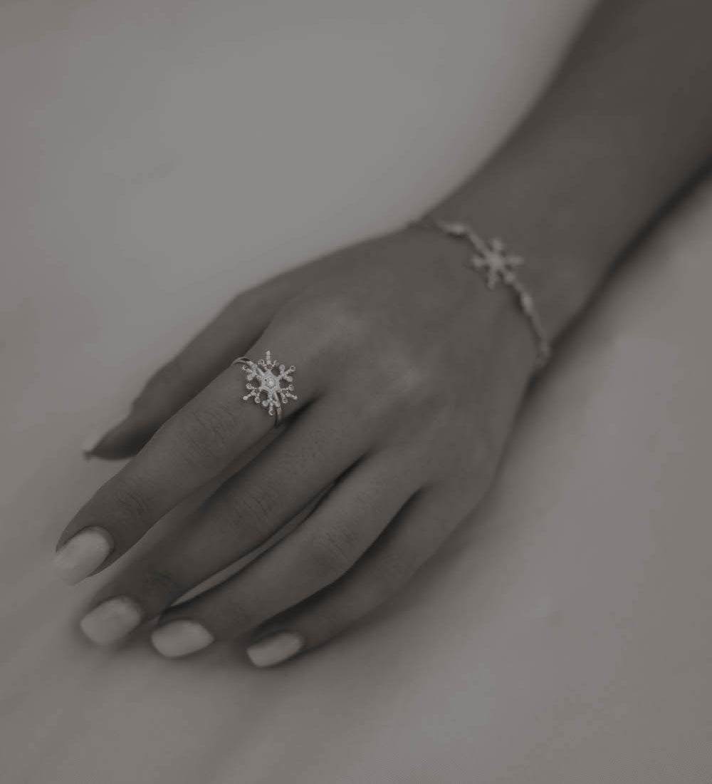 Silberner Snowflake Ice X Ring mit Zirkonia an Frauenhand.