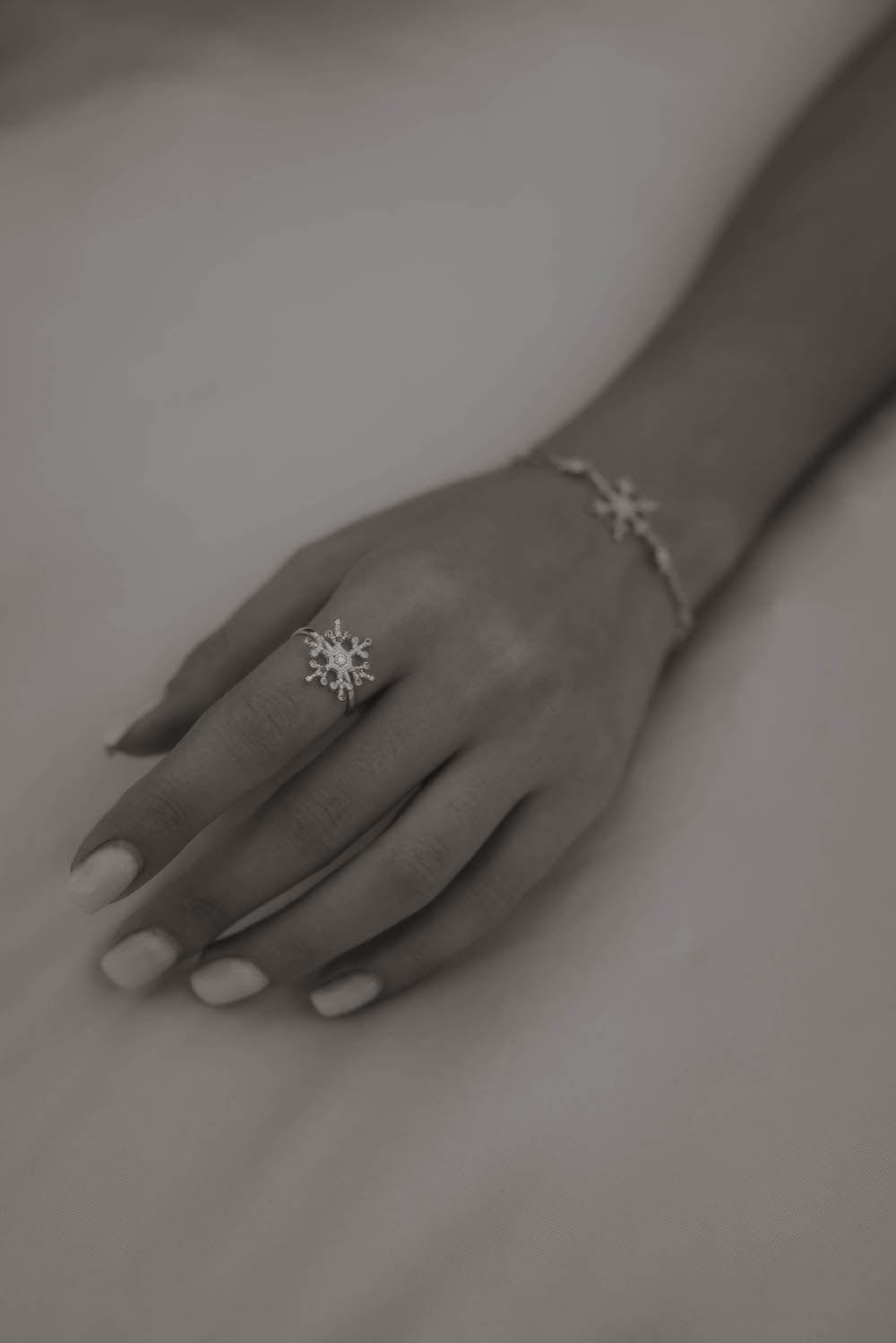 Silberner Snowflake Ice X Ring mit Zirkonia an Frauenhand.