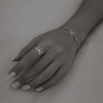 Silberner Snowflake Ice X Ring mit Zirkonia an Frauenhand.