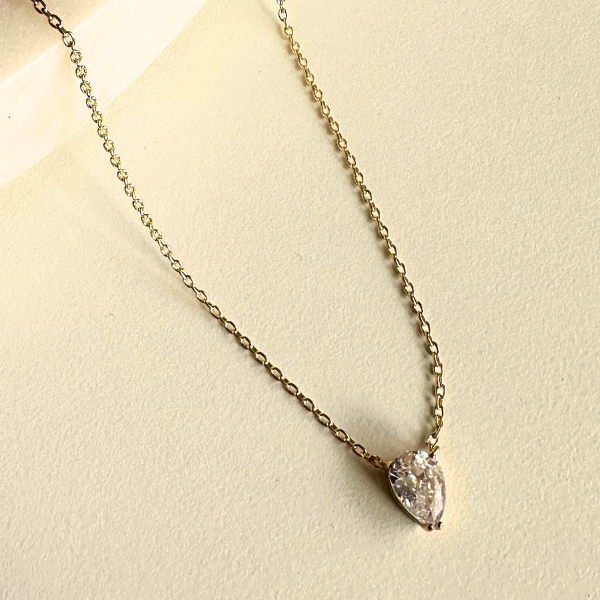 Zirkonia-Tropfen Anhänger an feiner goldener Kette – Solitär Drop Chain auf hellem Untergrund.