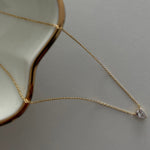 Zirkonia-Tropfen Anhänger an feiner goldener Kette – Solitär Drop Chain auf hellem Untergrund.