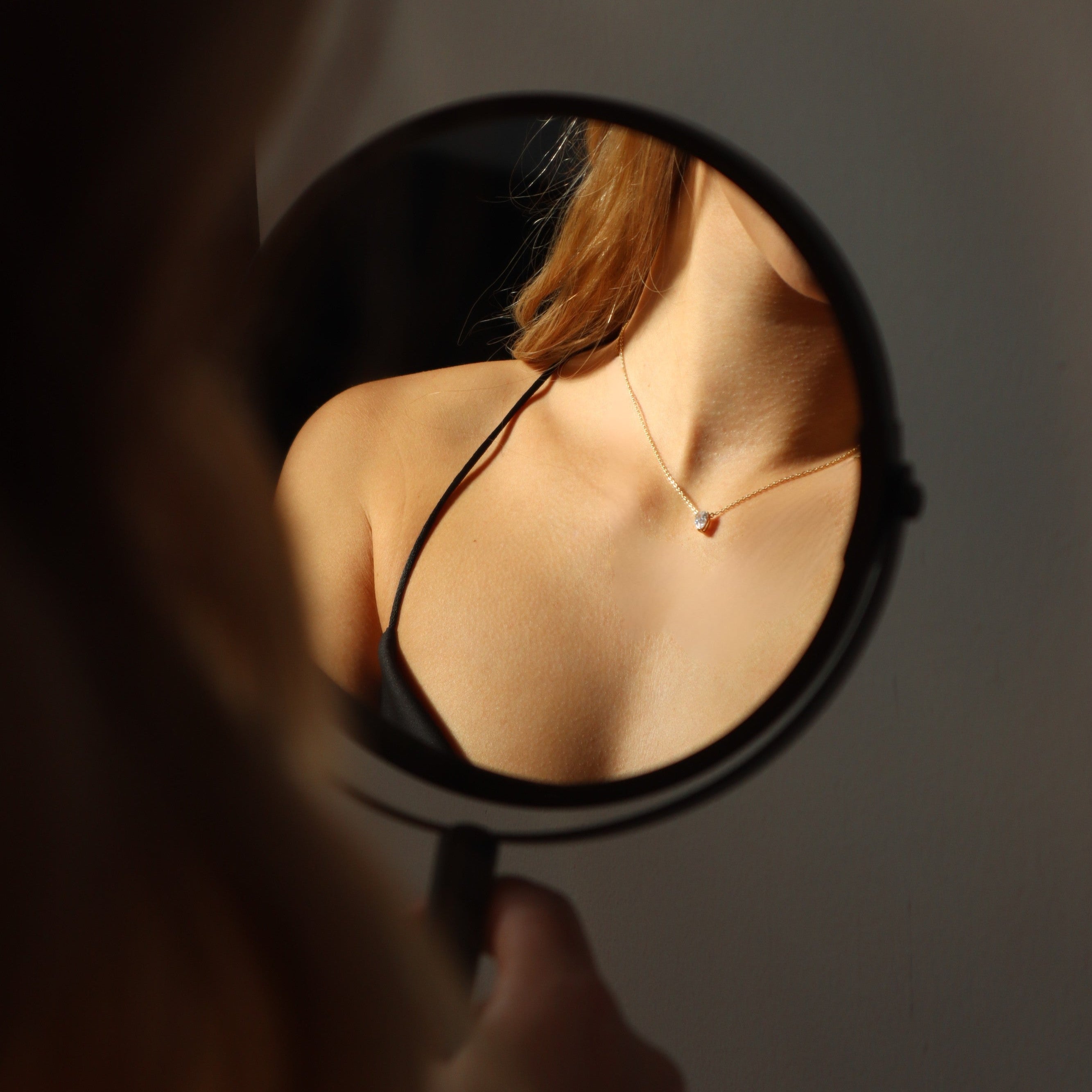 Minimalistische Solitär Drop Chain in Gold neben Spiegel, feine Kette mit Zirkonia-Tropfen.