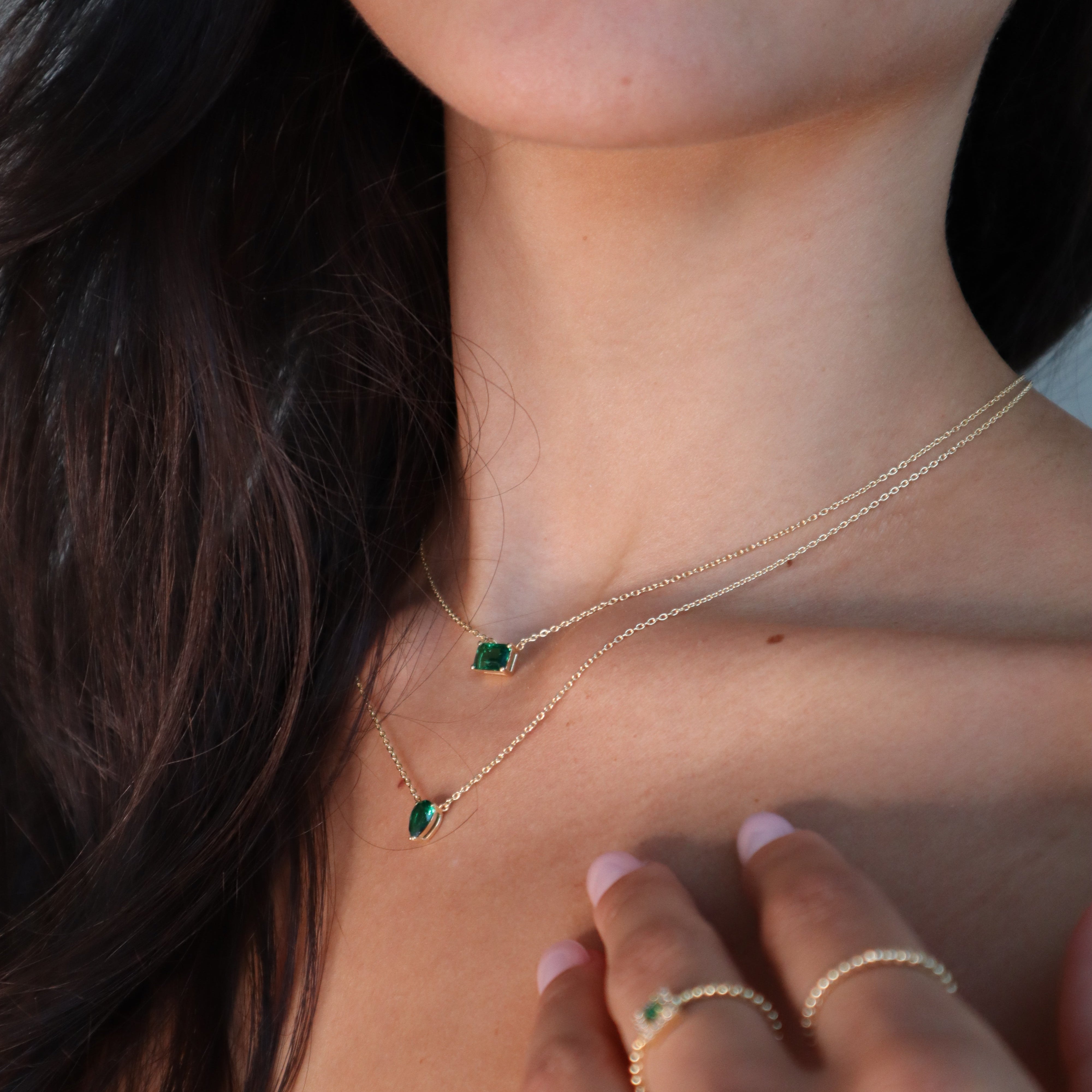 Layering-Look: Solitär Green Emerald Cut Chain in Gold am Hals getragen, eleganter grüner Stein.