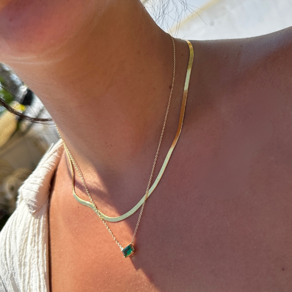 Solitär Green Emerald Cut Chain im Alltag getragen, grüne Emerald-Cut Kette kombiniert mit Goldkette.