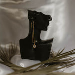 Einzelner Solitär Ohrring Gold an schwarzer Büste, langer Hänger mit Zirkonia.