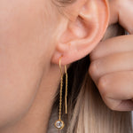 Solitär Ohrring Gold am Ohr getragen, langer Kettenhänger mit funkelndem Zirkonia.