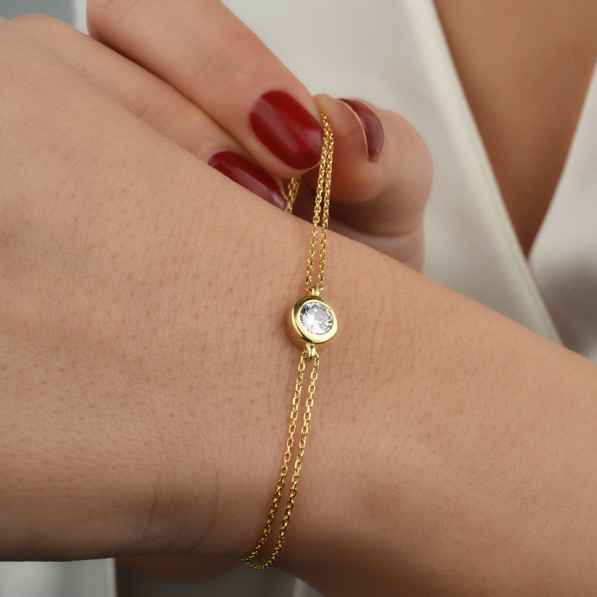 Solitaire Armband Gold am Handgelenk mit funkelndem Zirkonia – elegant & minimalistisch.