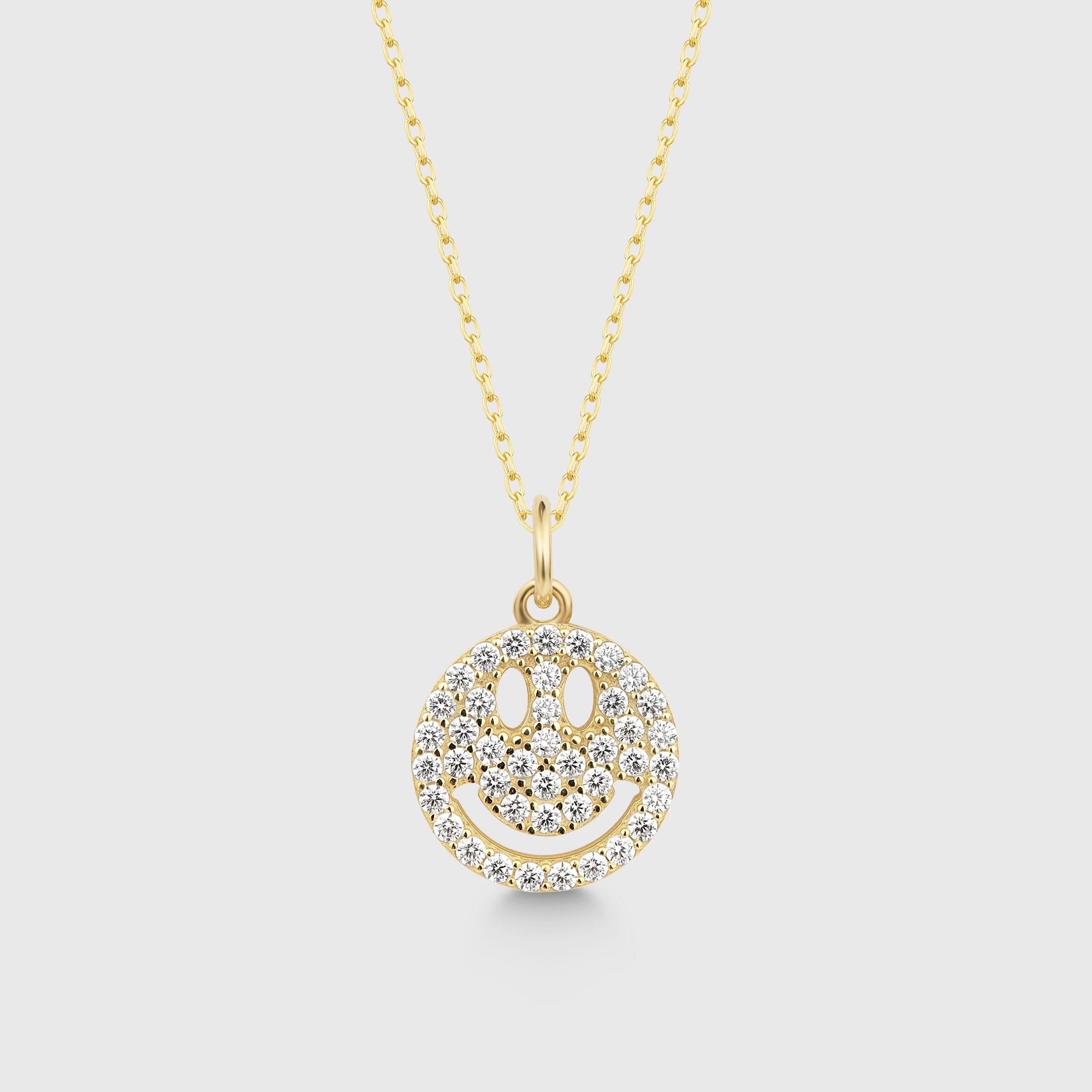 Goldene Sparkling Smilie Kette mit Zirkonia-Smileyanhänger auf hellem Hintergrund.