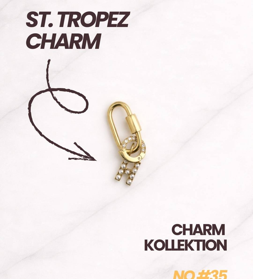 St. Tropez Charm Gold mit Karabiner, Zirkonia- und Perlen-Details in Nahaufnahme.