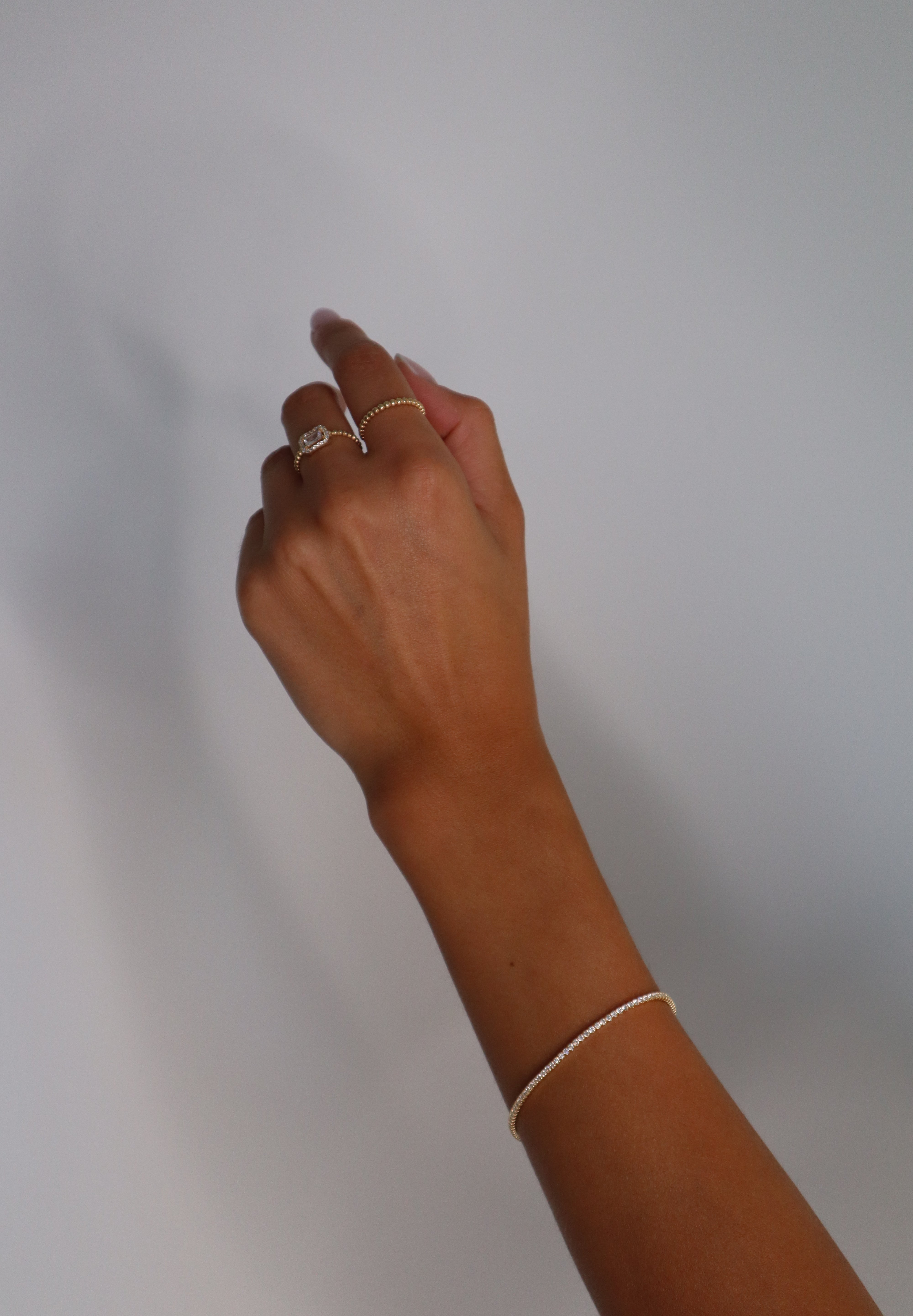 Tennis Armkette Mini in Gold am Handgelenk getragen, filigraner eleganter Look.