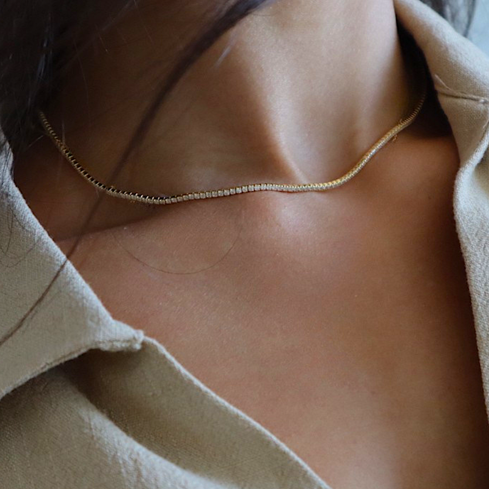 Tennis Kette Mini in Gold getragen am Hals – zarte Zirkonia Kette für elegante Layering-Looks.