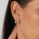 Goldene Zirkonia Creolen am Ohr im Layering – Three Line Pave S kombiniert mit zweitem Ohrring.