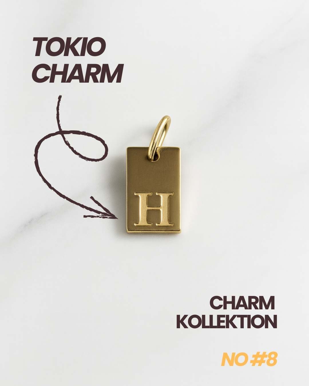 Detailaufnahme des goldenen Tokio Initial Anhängers mit Buchstabenprägung